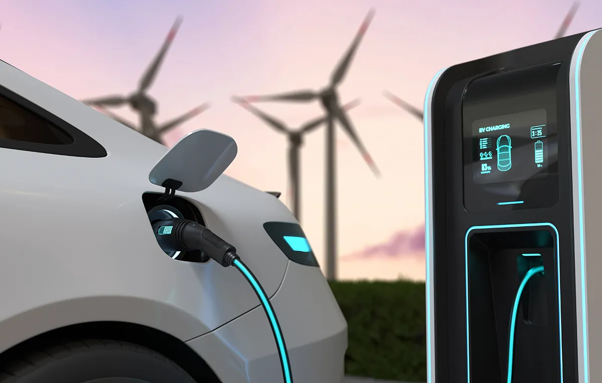 EV battery charging with clean renewable energy being generated by wind turbines.