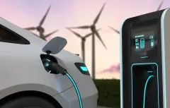EV battery charging with clean renewable energy being generated by wind turbines.