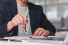 Close up businessman hand holding stamp for approving document. 