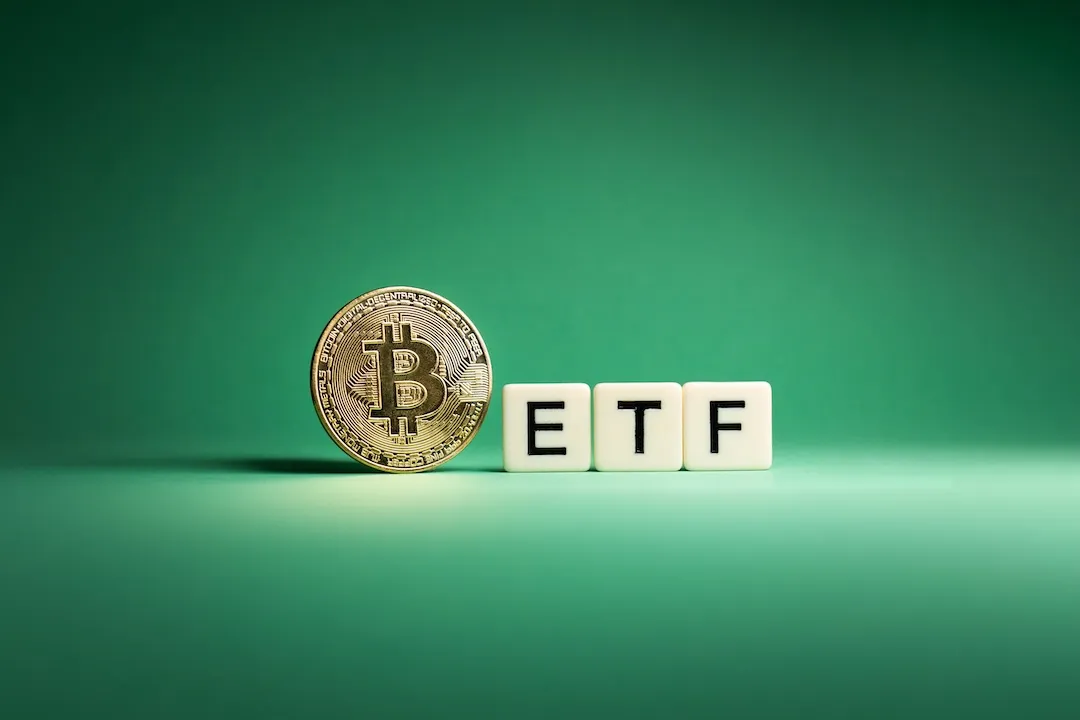 Golden Bitcoin facing camera next to three scrabble tiles spelling out ETF