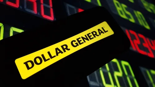 Dollar General company logo displayed on mobile phone against red and green stock ticker board