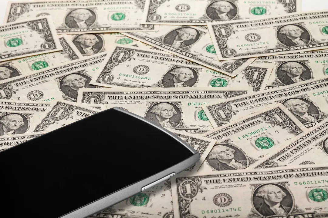 Phone on piles of dollars