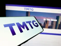 Mobile phone with logo of American company Trump Media Technology Group (TMTG) in front of business website. Focus on center of phone display.