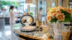 Cosmetics on ornate vanity with reflection and blooms
