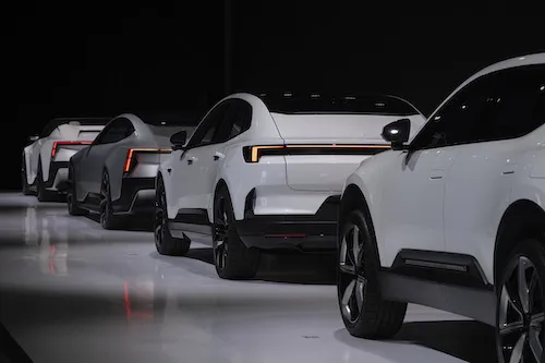 Four white Polestar cars lined up on dark background