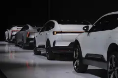 Four white Polestar cars lined up on dark background