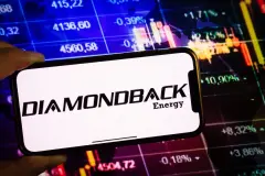 Smartphone displaying logo of Diamondback Energy company on stock exchange chart background