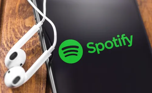 Spotify SPOT stock image logo on smartphone with headphones