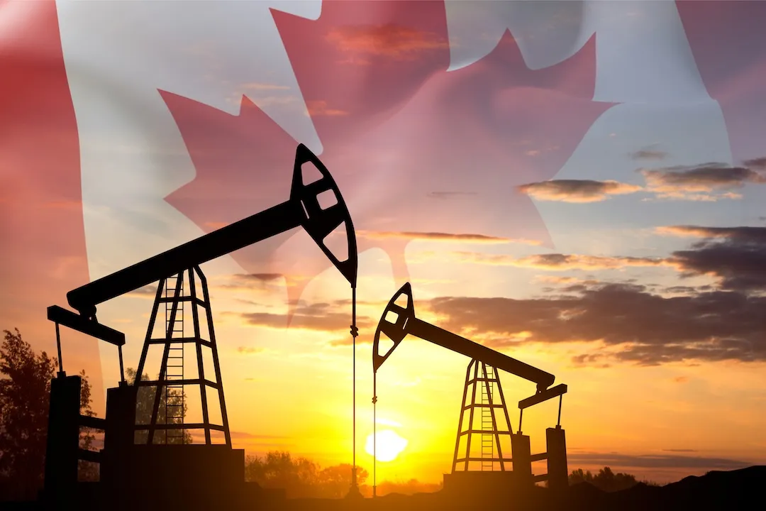 Silhouette of oil rigs against the sunset with Canada flag. Oil Industry concept