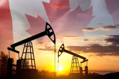 Silhouette of oil rigs against the sunset with Canada flag. Oil Industry concept