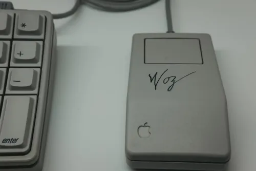 An early version of the Apple computer mouse with Woz signature on it and Apple icon.