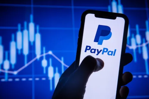 Paypal finance service logo on a smartphone. The image captures a smartphone with the PayPal logo on its screen, held against a backdrop of indistinct stock market charts, highlighting PayPal's releva...