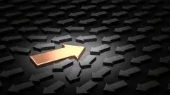 One golden arrow pointing in the opposite direction to a sea of grey arrows.