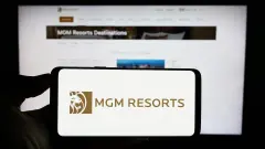 MGM Resorts International Logo on Smartphone against blurred website background.