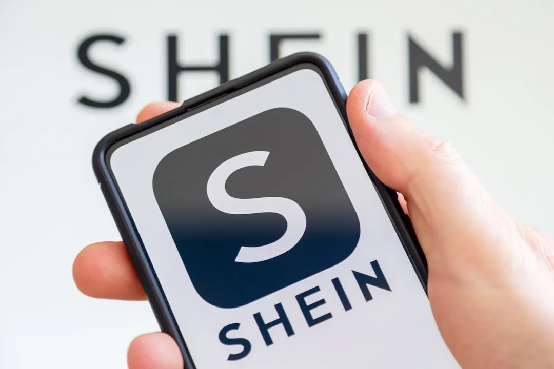 Black Shein logo on Smartphone screen