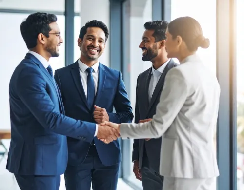 business team celebrating a deal with a handshake and smiles.