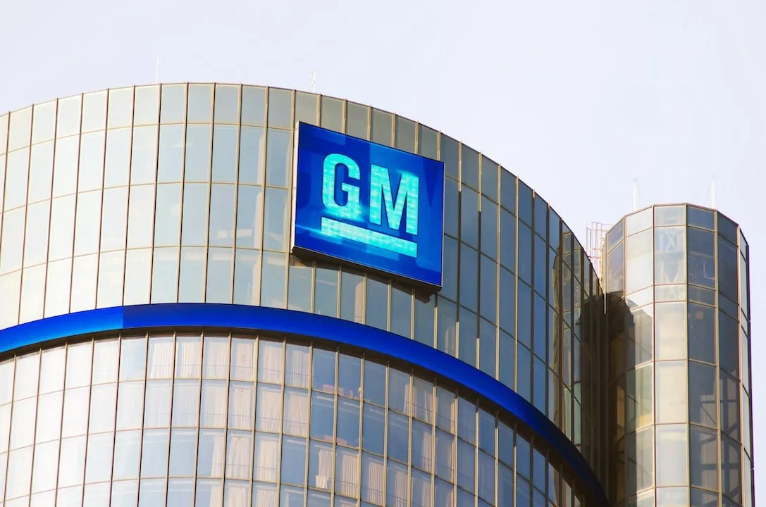 GM's Renaissance Center Headquarters stands tall under the Detroit sky, its emblem illuminated as a beacon of the city's automotive legacy.