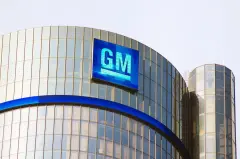 GM's Renaissance Center Headquarters stands tall under the Detroit sky, its emblem illuminated as a beacon of the city's automotive legacy.