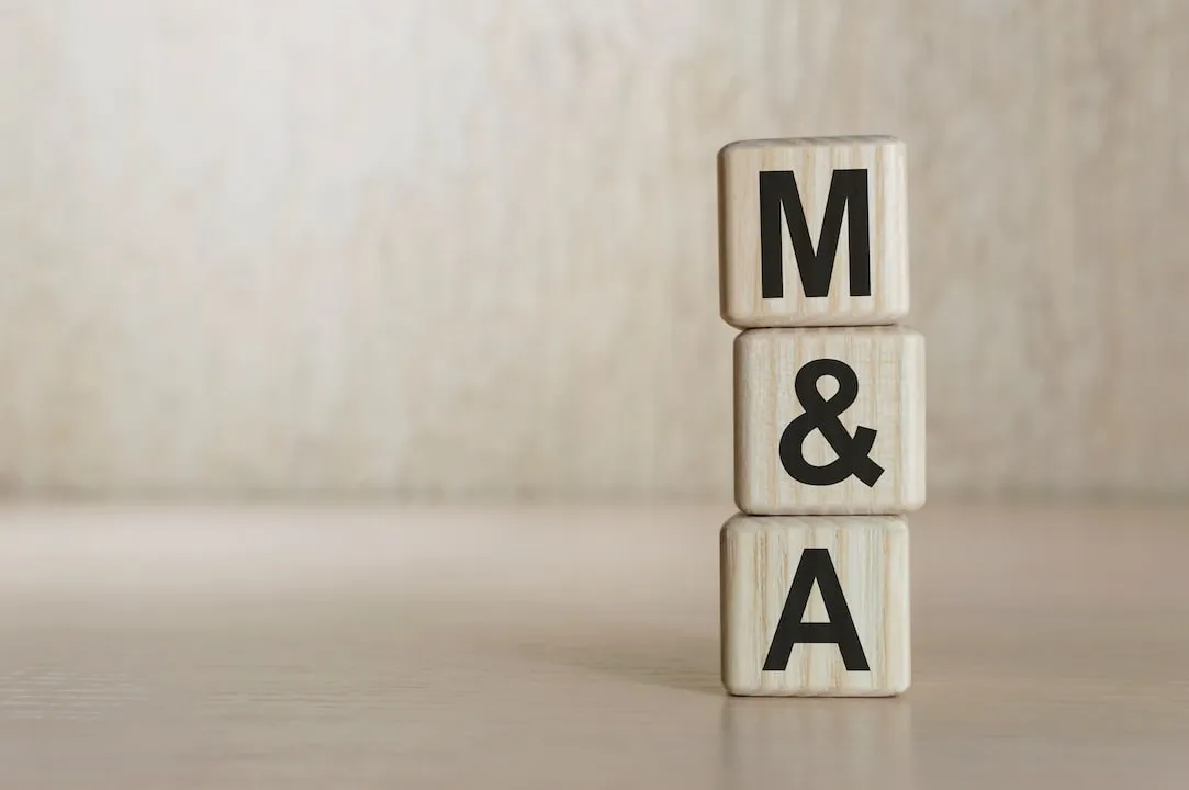 Stacked blocks spelling 'M&A' symbolize mergers and acquisitions in the business sector.