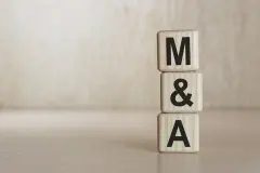  Stacked blocks spelling 'M&A' symbolize mergers and acquisitions in the business sector.