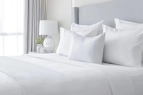 Comfortable hotel room with perfectly made bed and decorative pillows