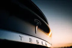 Tesla Badge on car bumper in sunset