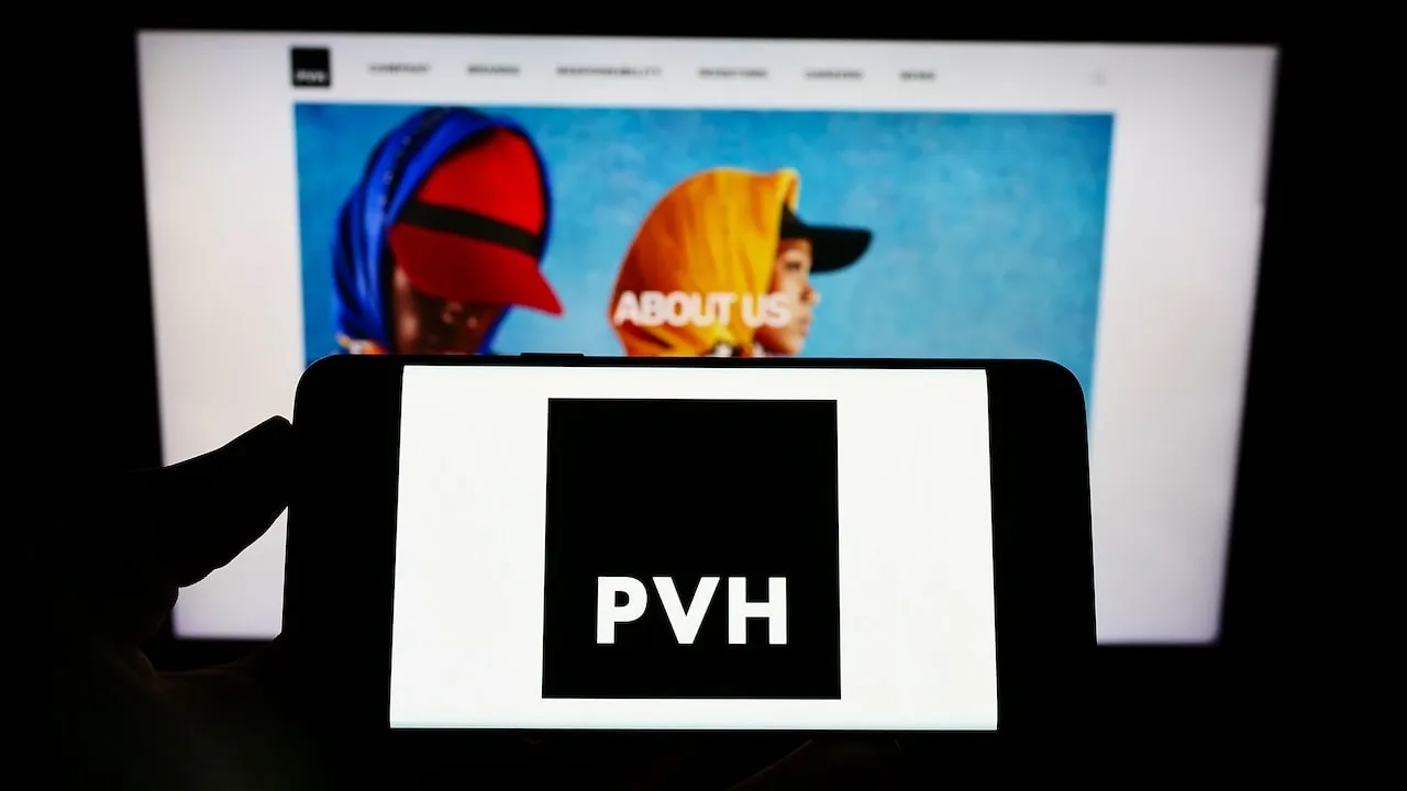 PVH Corp Logo on phone with Website on Screen in background