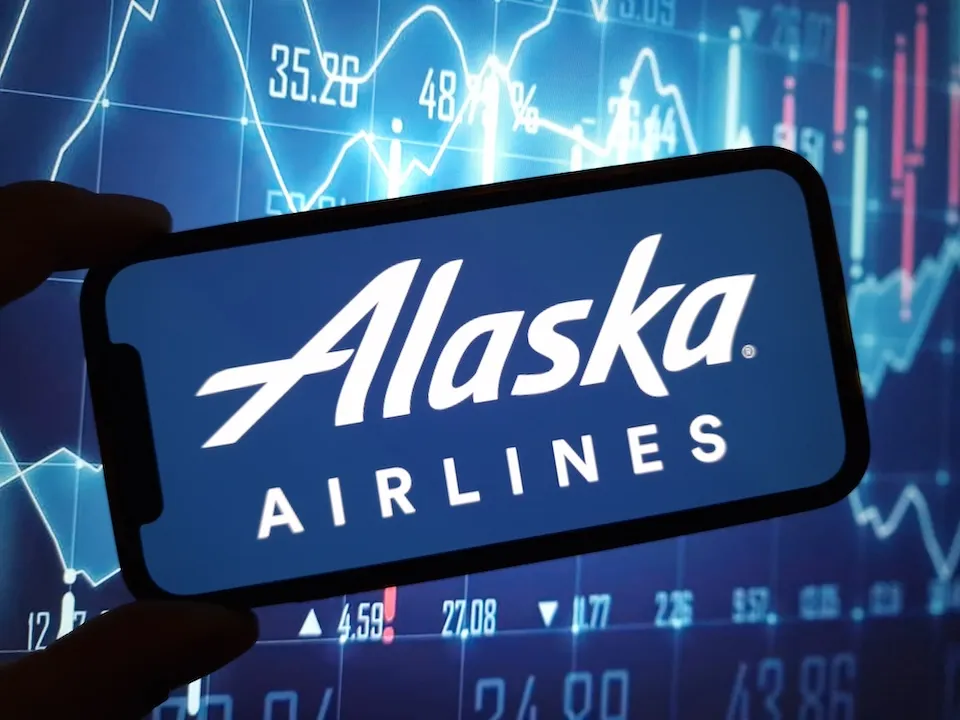 Alaska Airlines Logo on Smartphone against stock chart backdrop