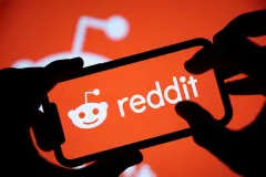 Reddit logo on orange background on smartphone screen