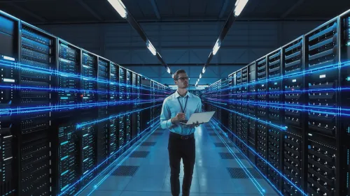 Futuristic Concept: Data Center Chief Technology Officer Holding Laptop, Standing In Warehouse, Information Digitalization Lines Streaming Through Servers. SAAS, Cloud Computing, Web