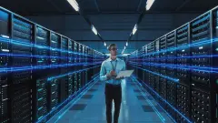 Futuristic Concept: Data Center Chief Technology Officer Holding Laptop, Standing In Warehouse, Information Digitalization Lines Streaming Through Servers. SAAS, Cloud Computing, Web