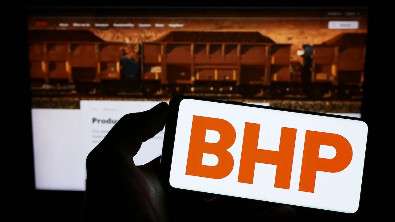 Stuttgart, Germany - 06-17-2023: Person holding smartphone with logo of Australian mining company BHP Group Limited on screen in front of website. Focus on phone display.
