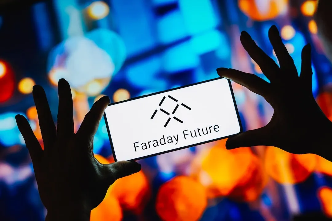 Faraday Future logo on smartphone held between two hands