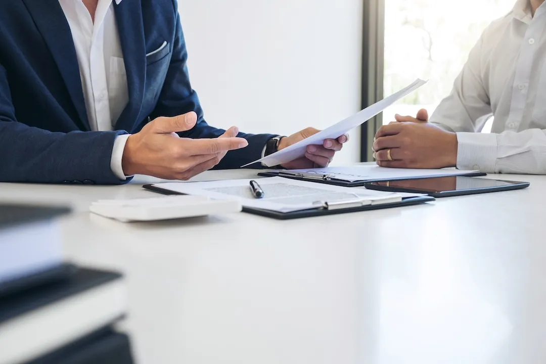 businessman reviewing document at office workplace with computer laptop. legal expert, professional lawyer reading and checking financial documents or insurance contract