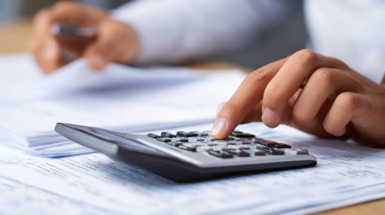 calculator assisting in financial analysis among paperwork on a desk.