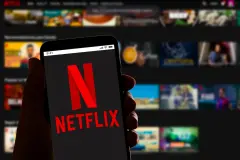 Netflix Logo on Smartphone Handset screen with Netflix Shows in background NFLX stock