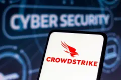 Crowdstrike logo on smartphone with Cyber Security written in the background.