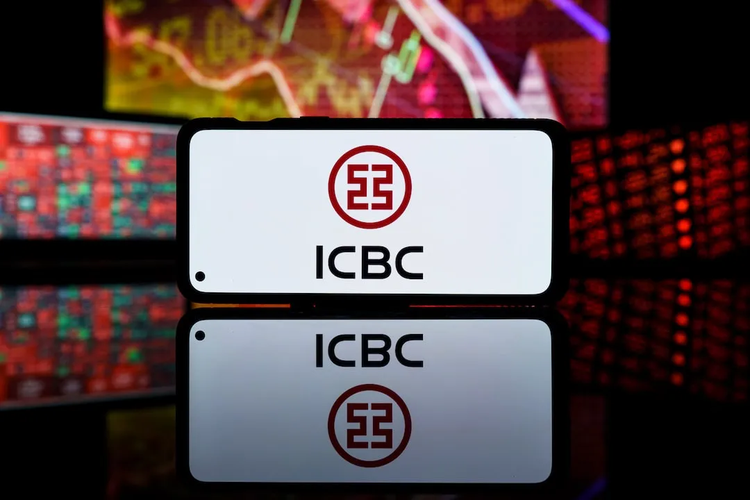 The Industrial & Commercial Bank of China Ltd. ICBC Logo on smartphone - sidelong view against blurred trading screens
