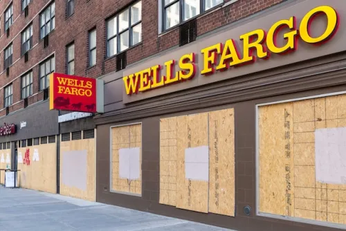 Wells Fargo windows boarded up with plywood on empty street