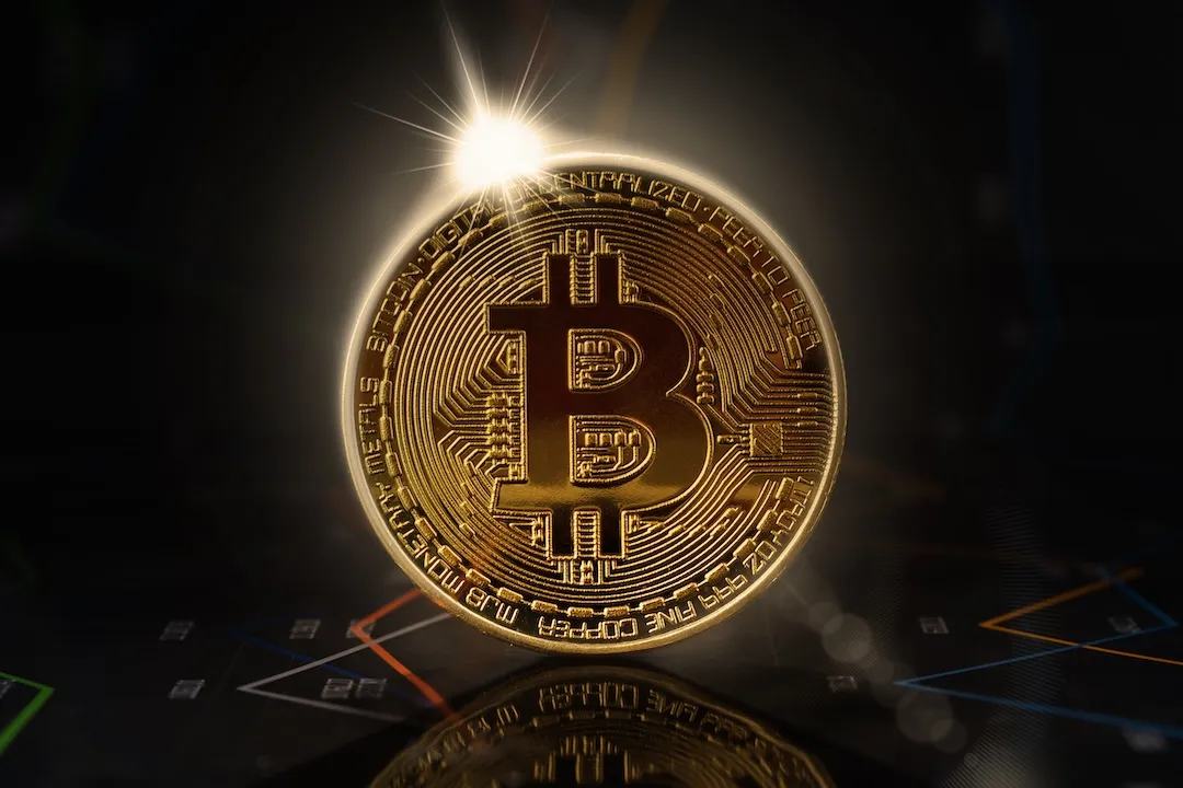 Sunrise behind gold bitcoin standing on financial graphs for cryptocurrency prices