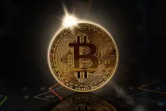 Sunrise behind gold bitcoin standing on financial graphs for cryptocurrency prices