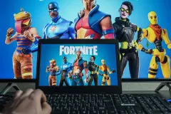 PC gaming. Playing Fortnite video game on computer. Disney invests.