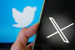 X logo on smartphone screen Twitter Bird Logo behind