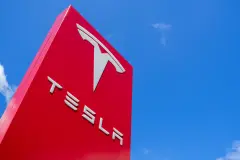 Red Tesla sign against blue sky