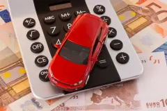 Red toy car on top of calculator