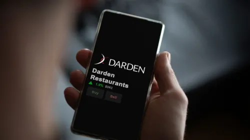 The logo of Darden Restaurants on the screen of an exchange. Darden Restaurants price stocks, $DRI on a device.